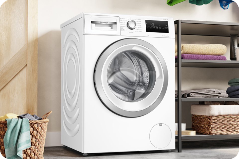 A white Bosch washing machine in a laundry room setup.